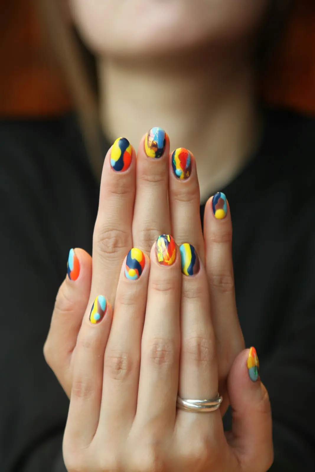 Mains portant un nail art coloré